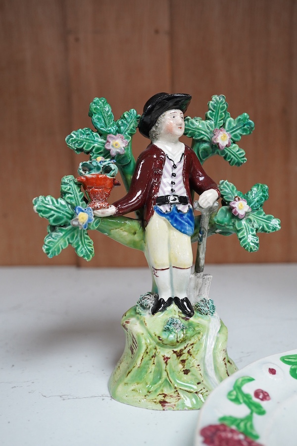 Two early 19th century Walton pearlware figures, the first a man holding a basket flowers, the second a cider costrel, tallest 19.5cm, together with a pearlware nursery plate (3). Condition – some restoration otherwise f